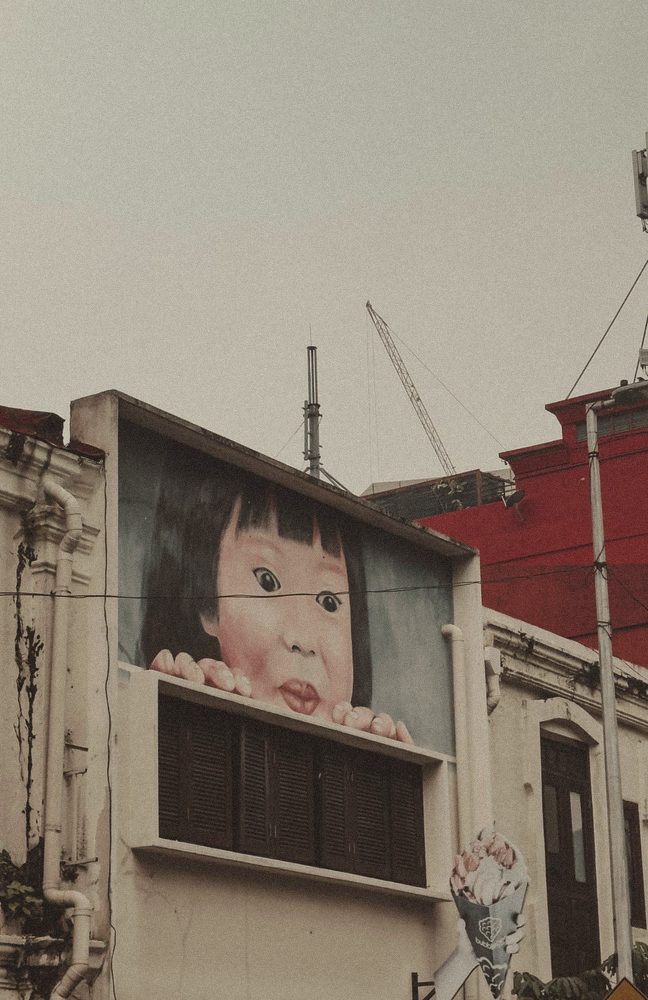 Mural of a girl peeking over a window