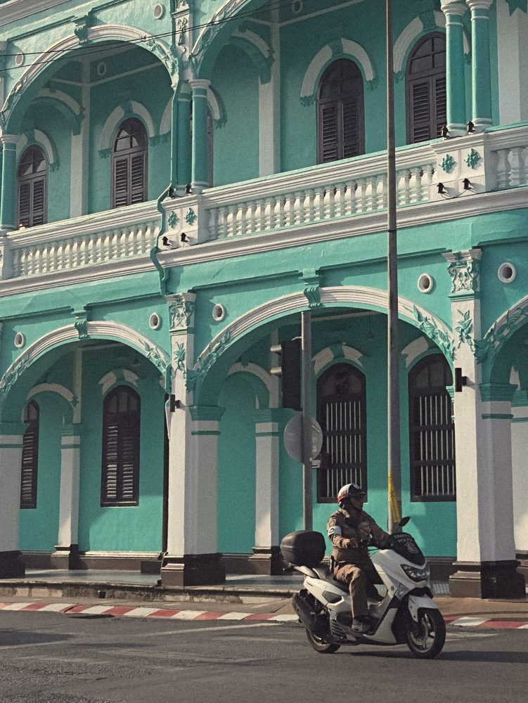 Turquoise shophouse and a police scooter